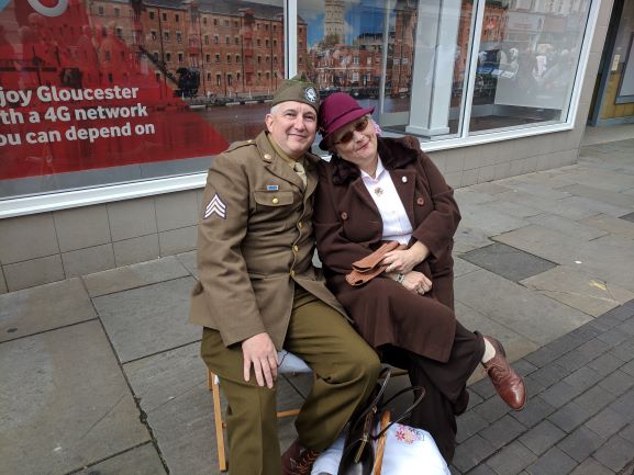 Picture of a member of the public dressed in 1940's American Uniform, sitting on a bench with his beau
