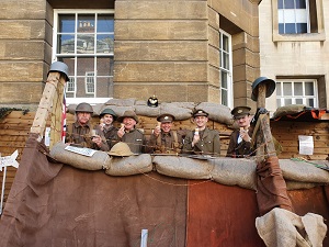 Photo of GCN volunteers dress as WW1 soldiers, eating icecream in the GLOS100 Trench